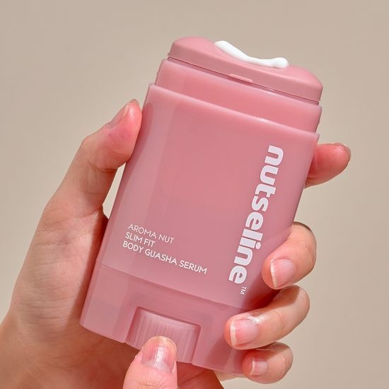 Hand holding NUTSELINE Aroma Nut Slim Fit Body Guasha Serum 60ml bottle