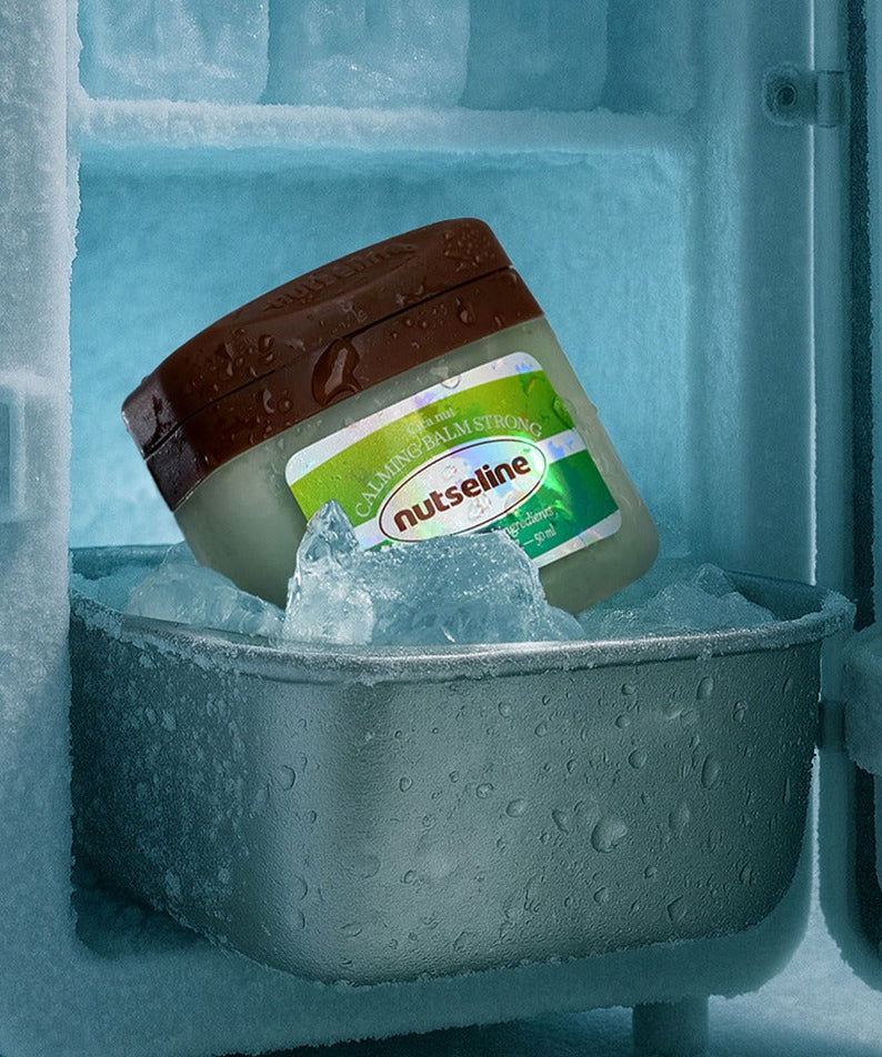NUTSELINE Cica Nut Calming Balm Strong 50ml jar in freezer surrounded by ice, showcasing cooling effect for calming relief.
