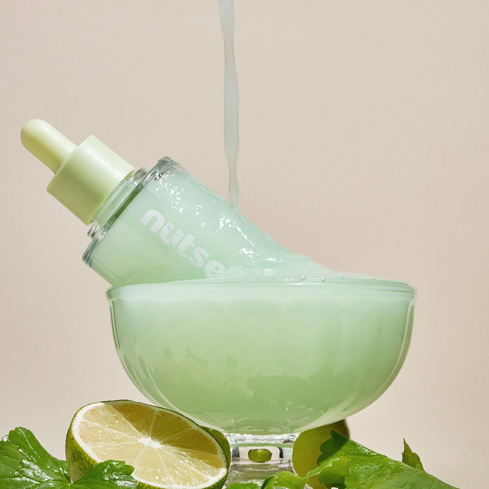 NUTSELINE Cica Nut Hyal Ampoule 90ml in decorative display with lime, showcasing product texture and natural ingredients.
