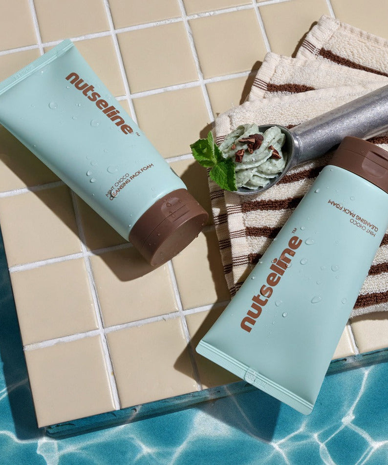 NUTSELINE Mint Chocolate Cleansing Pack Foam 130g tubes on a tiled surface by the pool, showcasing mint chocolate texture and design.
