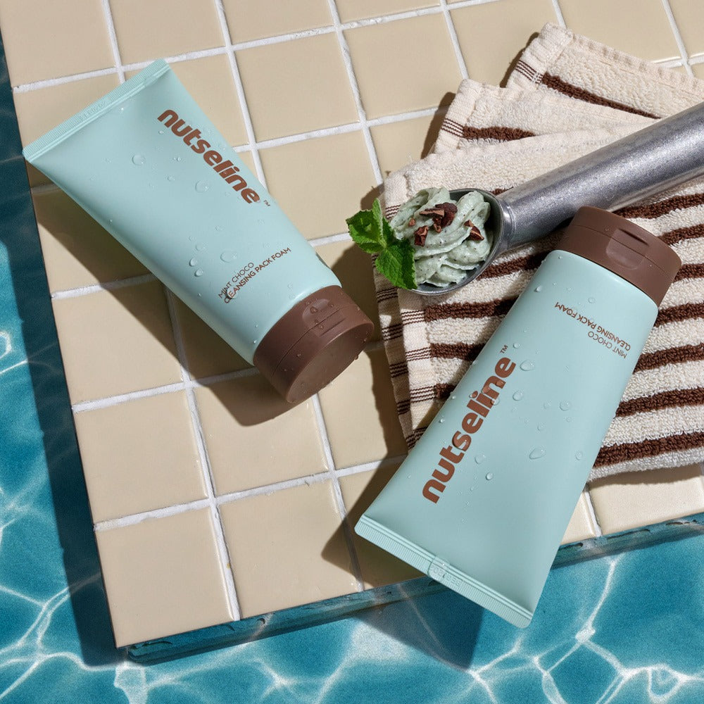 NUTSELINE Mint Chocolate Cleansing Pack Foam 130g tubes on a tiled surface by the pool, showcasing mint chocolate texture and design.