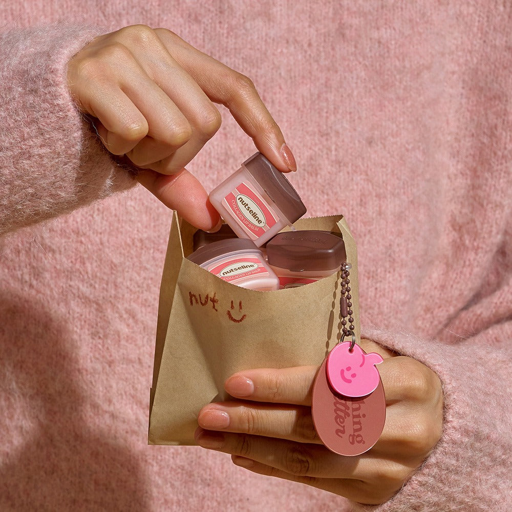 NUTSELINE Super Nut Collagen Keyring Lip Balm 11ml in a paper bag with pink keyring.