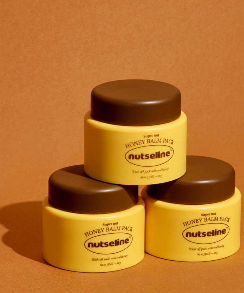 Three jars of NUTSELINE Super Nut Honey Balm Pack 100g stacked on a brown background