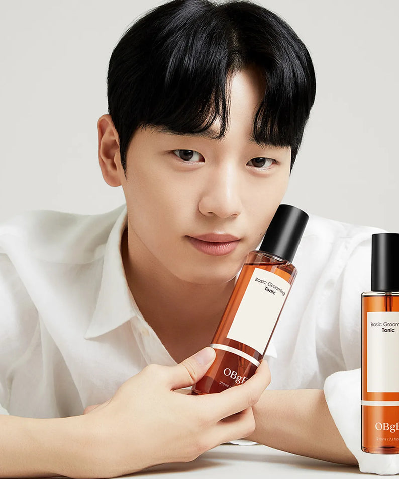 Gentleman Korea model holding OBGE Basic Grooming Tonic 210ml bottle in minimalist studio shot for men's skincare