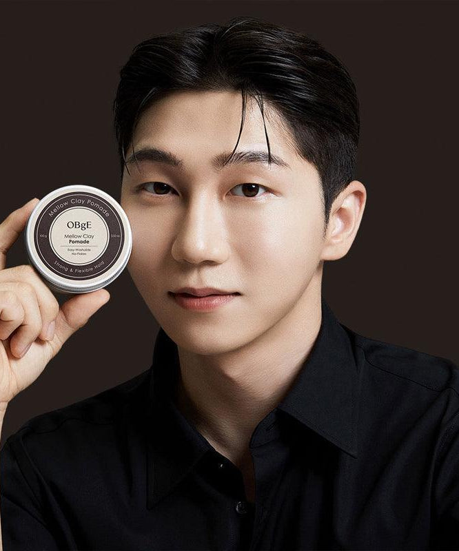 OBGE Mellow Clay Pomade 100g held by a Korean gentleman model in black shirt for Gentleman Korea, premium men’s styling clay pomade