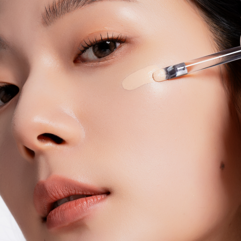 Close-up of applying OIAD Cover Perfecting Mirror Brushed Concealer on skin for flawless finish