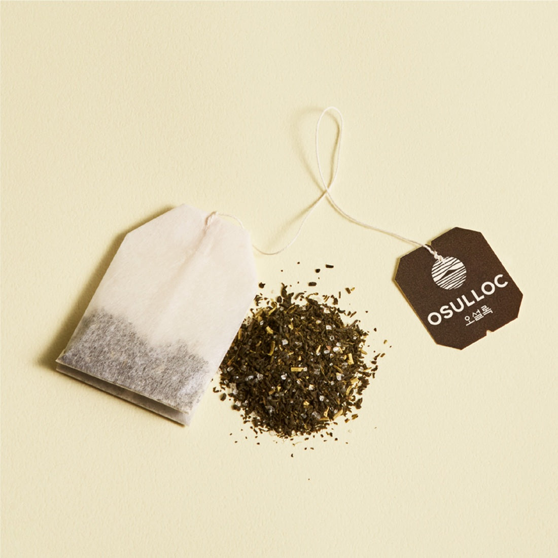 OSULLOC Canola & Apricot Tea 20 P in teabag form with loose tea on a beige background.