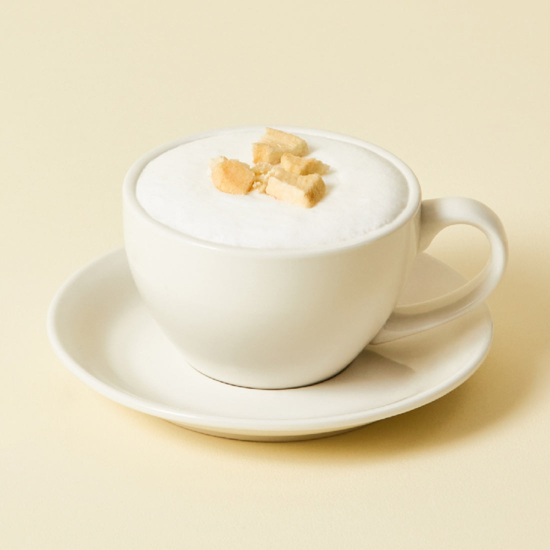 Cup of OSULLOC Chamomile Blend 10 p. tea with frothy top, served in a white cup on a saucer.