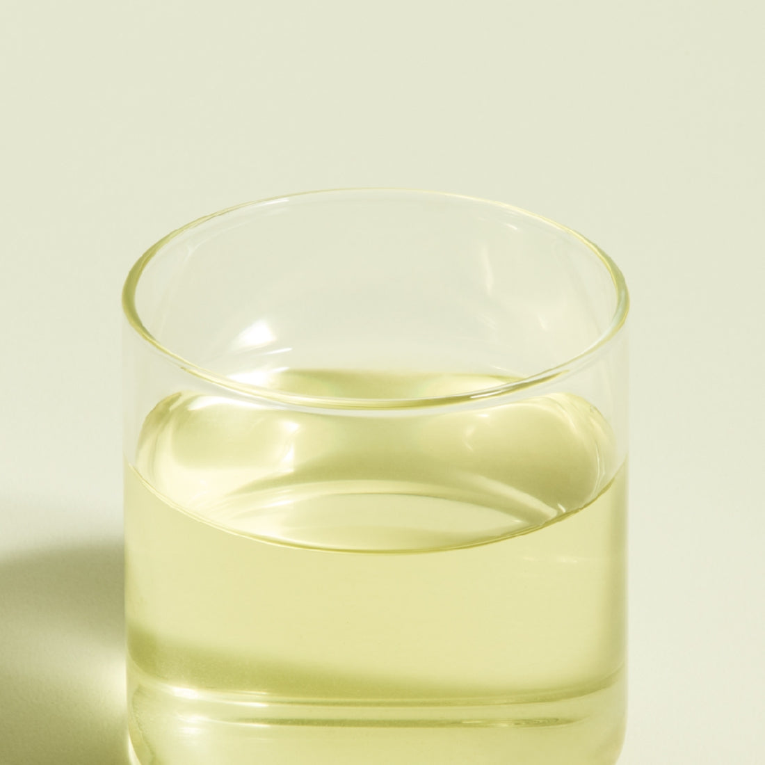 Glass of brewed OSULLOC Jeju Pure Green Tea 20 P with light green color
