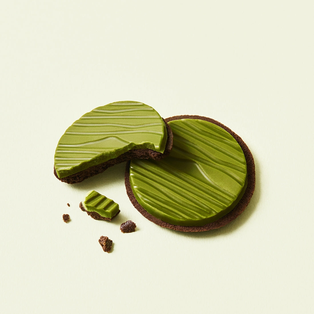Two OSULLOC Signature Biscuits 10 P featuring green tea infused chocolate, with one cookie partially broken, on a light background.