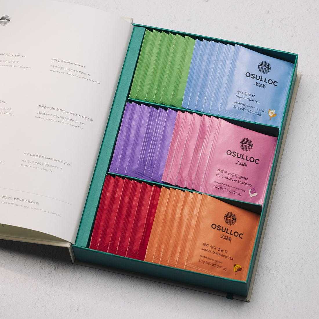 OSULLOC Tea Variation O 6 types in a gift box with colorful tea sachets displayed elegantly on a table.
