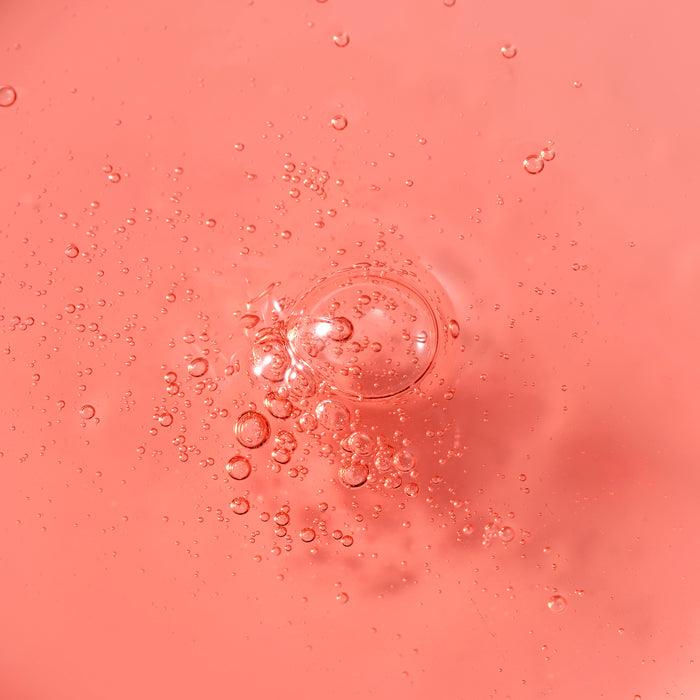 Close-up of PARNELL AHA 9.12 Caremic Wash-Off Serum 30ml texture with bubbles against a pink background