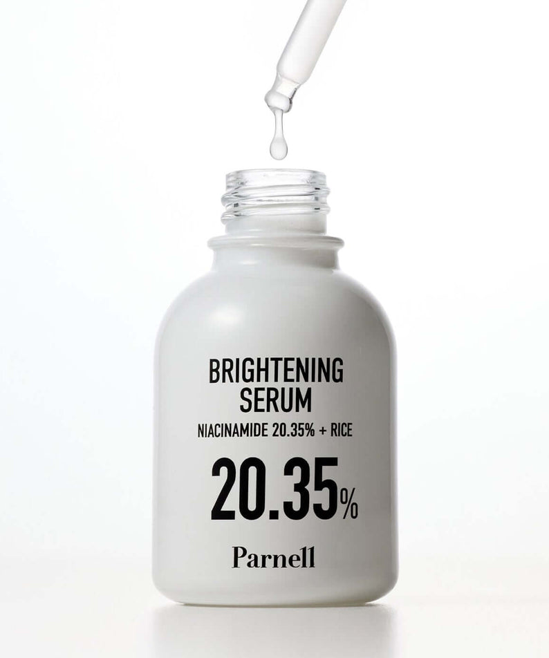 PARNELL Niacinamide 20.35 Rice Brightening Serum 30ml bottle with dropper and clear liquid emerging from it.