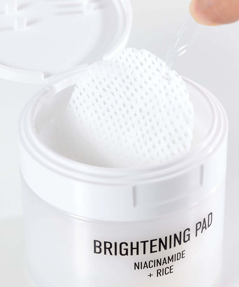 Open container of PARNELL Niacinamide Rice Brightening 60 pads with close-up of textured pad and packaging details.