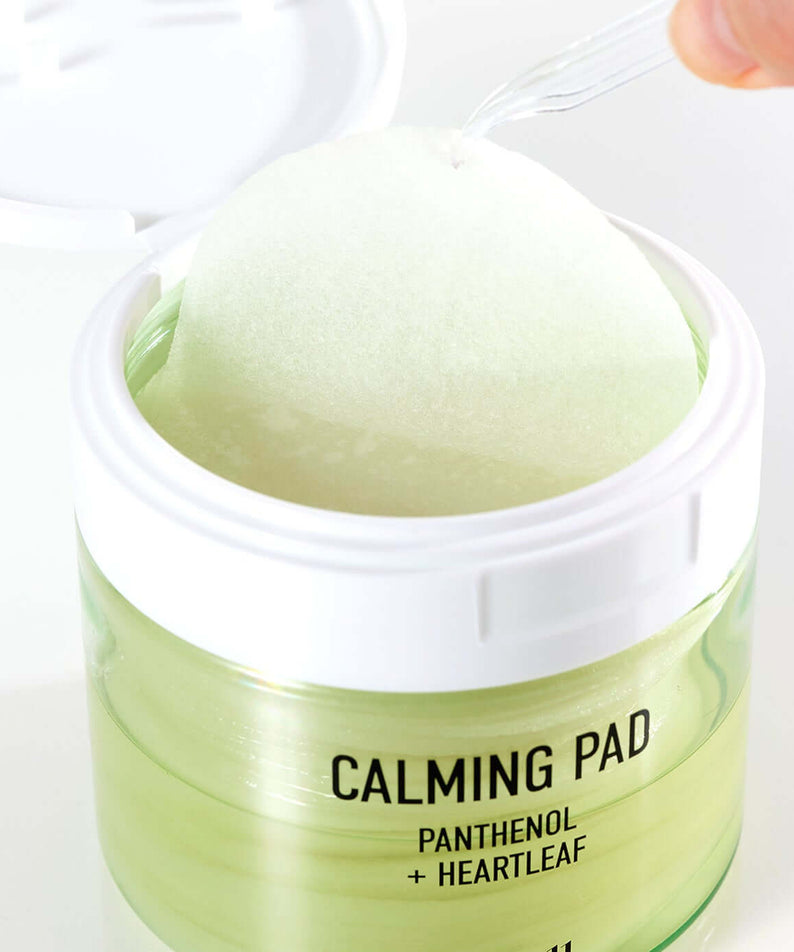 PARNELL Panthenol Heartleaf Calming Pad 60pads being picked with a tool from an open jar, showcasing product design and texture.
