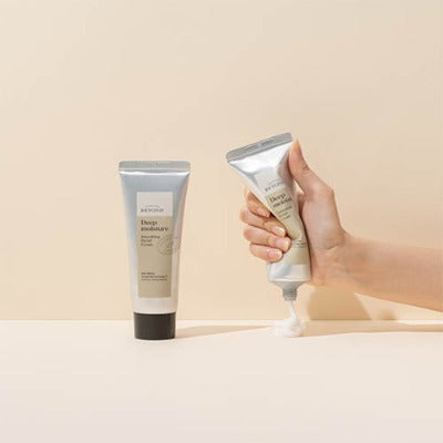 Hand squeezing PASSION & BEYOND Deep Moisture Soothing Facial Cream 100ml tube with another tube standing beside it on a neutral background.