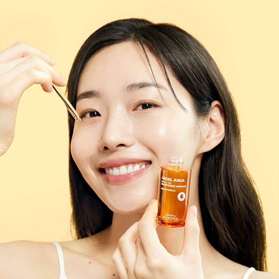 Woman applying PASSION&BEYOND Angel Aqua Vita C 7% Blemmish Ampoule 30ml to face with dropper.