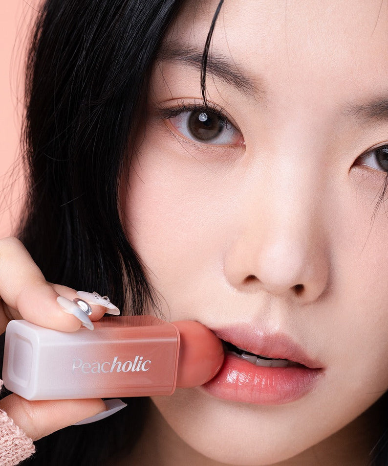 Woman applying PEACHOLIC Water Glow Lip Tint for glossy lips