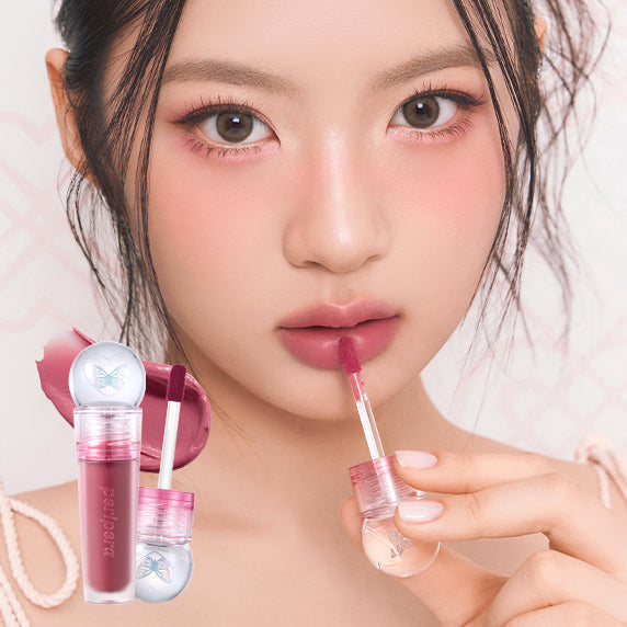 Model applying PERIPERA Ink The Jellable Tint in pink shade to lips, showcasing vibrant color and glossy finish