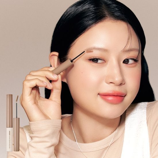 Woman applying PERIPERA Speedy Skinny Brow Mascara to her eyebrows for precise styling.