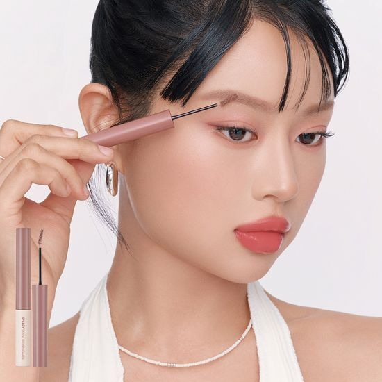 Woman applying PERIPERA Speedy Skinny Brow Mascara for precise eyebrow styling.