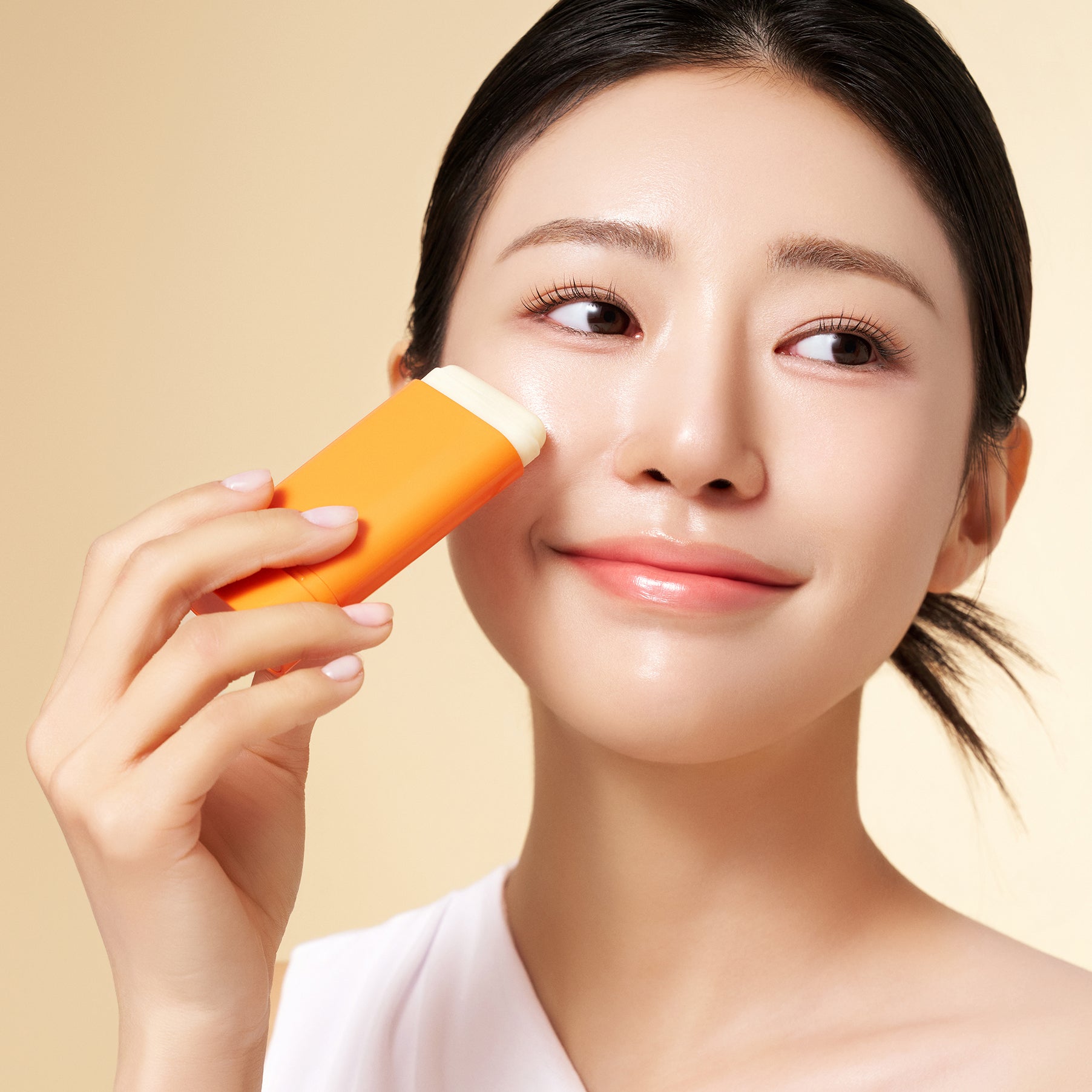 Woman applying PURITO Daily Soft Touch Sun Stick SPF50+PA++++ on face, showcasing skincare product in use.