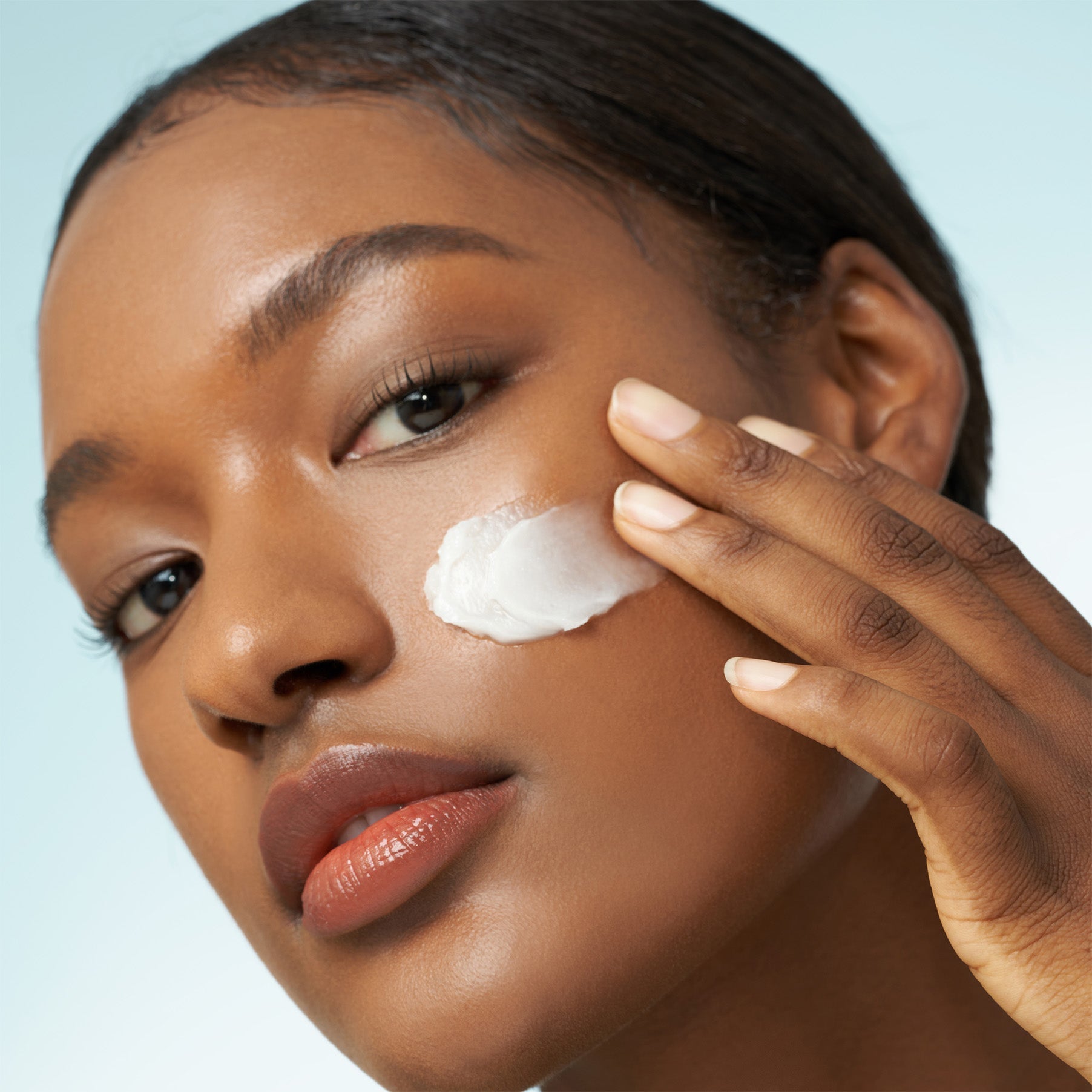 Woman applying PURITO From Green Avocado Cleansing Balm 100ml to her face for skincare.