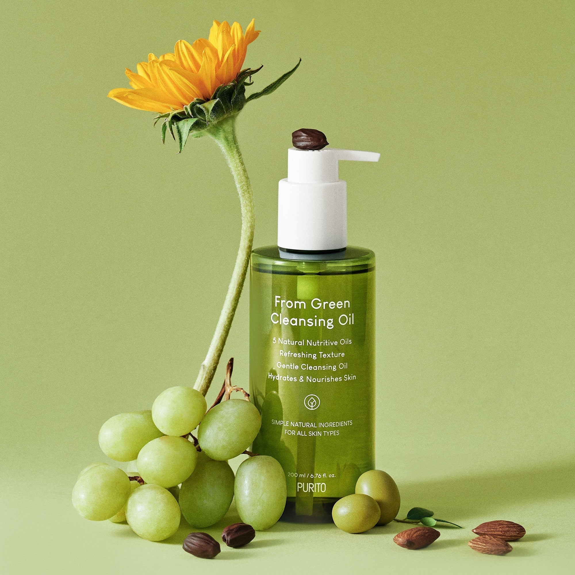 PURITO From Green Cleansing Oil 200ml bottle with flower, grapes, and nuts on green background