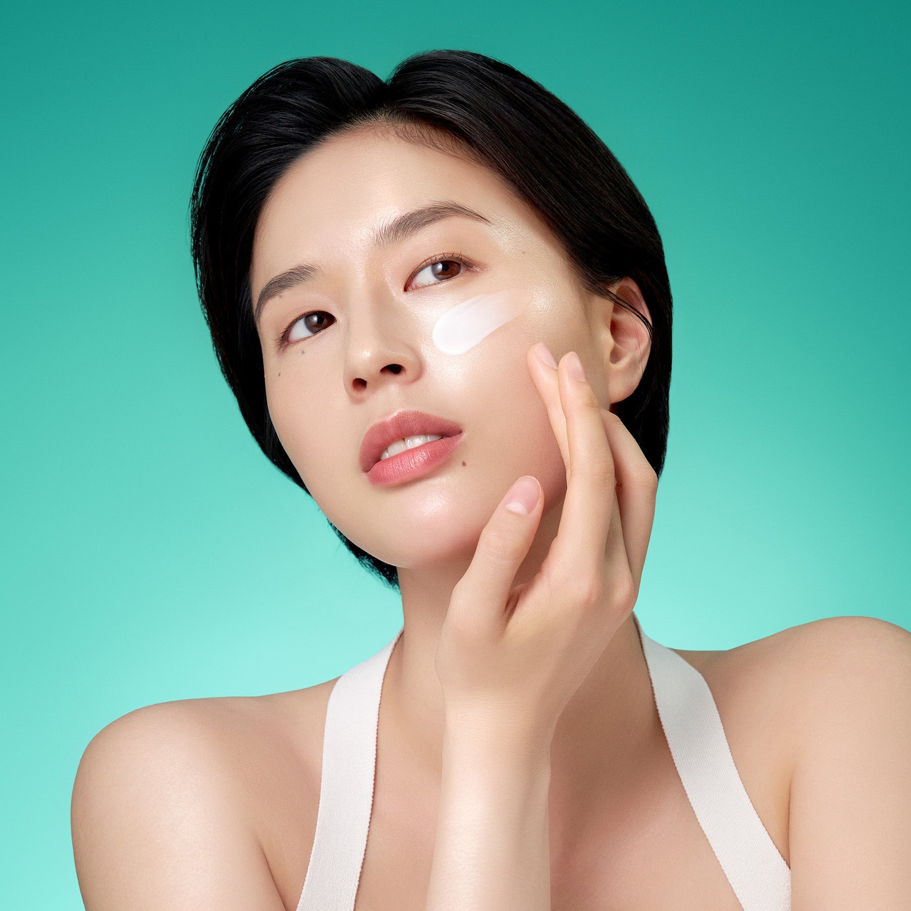 Woman applying PURITO Mighty Bamboo Panthenol Cream 100ml on face, showcasing skincare routine.