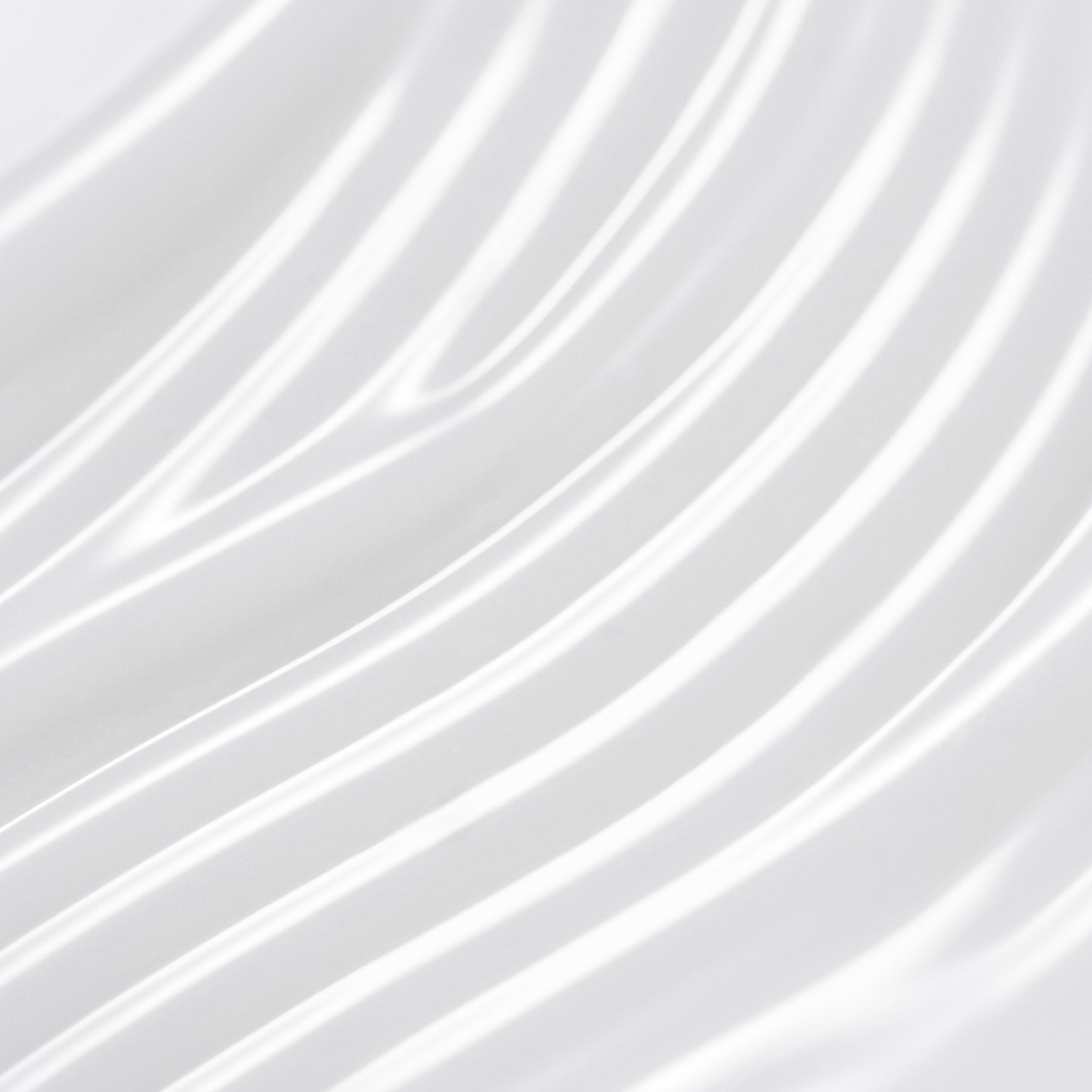 Close-up of smooth, white flowing fabric texture, showcasing intricate waves and patterns.