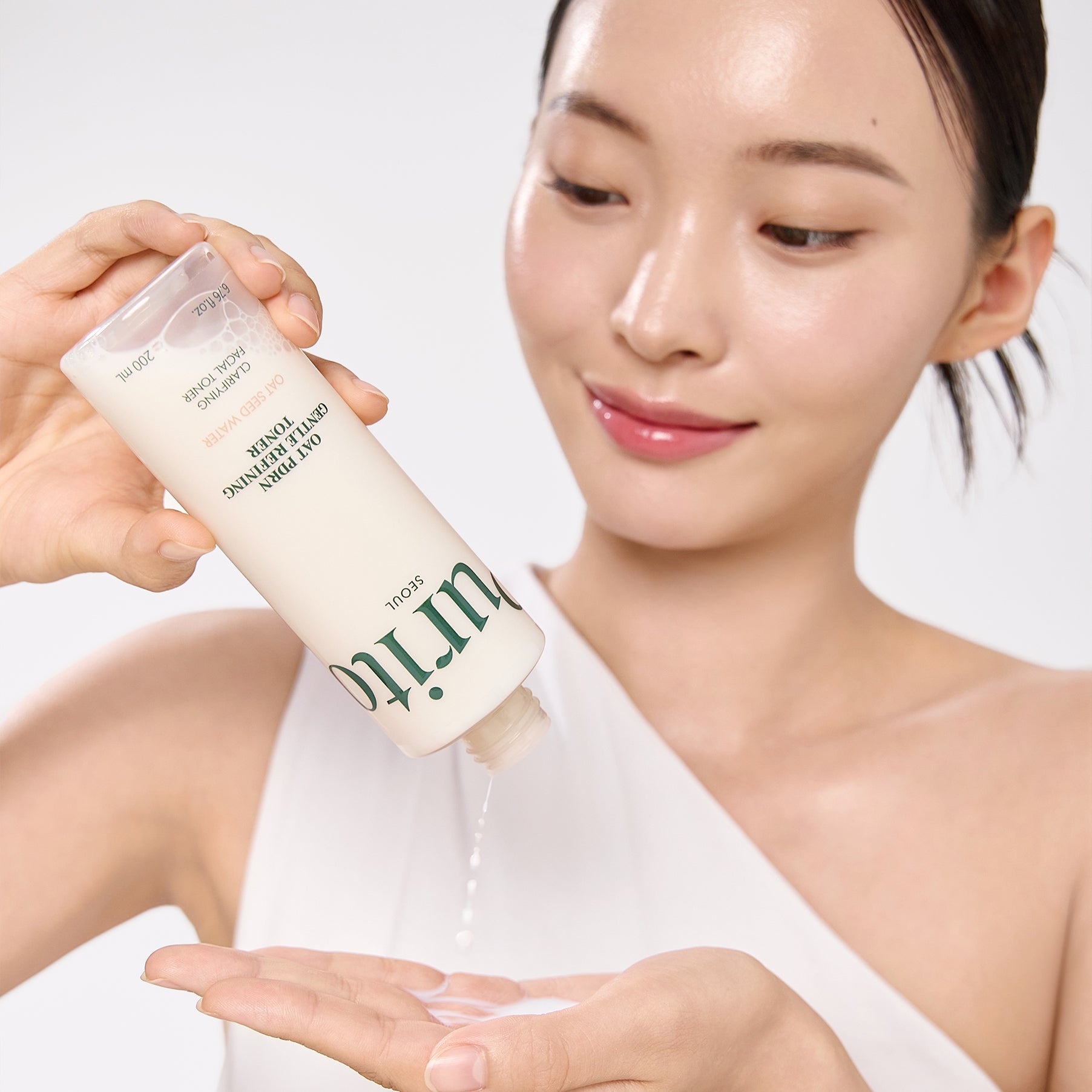 Woman using PURITO Oat PDRN Gentle Refining Toner 200ml skincare product