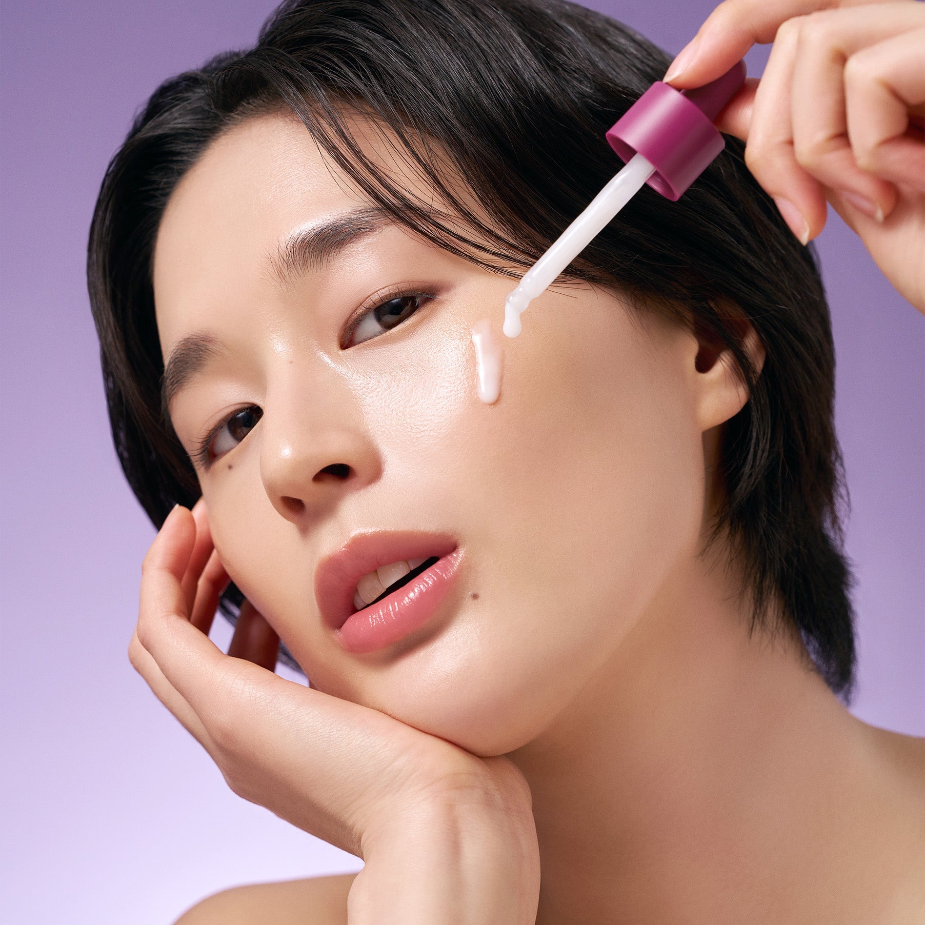 Model applying PURITO Timeless Bloom Bakuchiol Serum 30ml on face with dropper