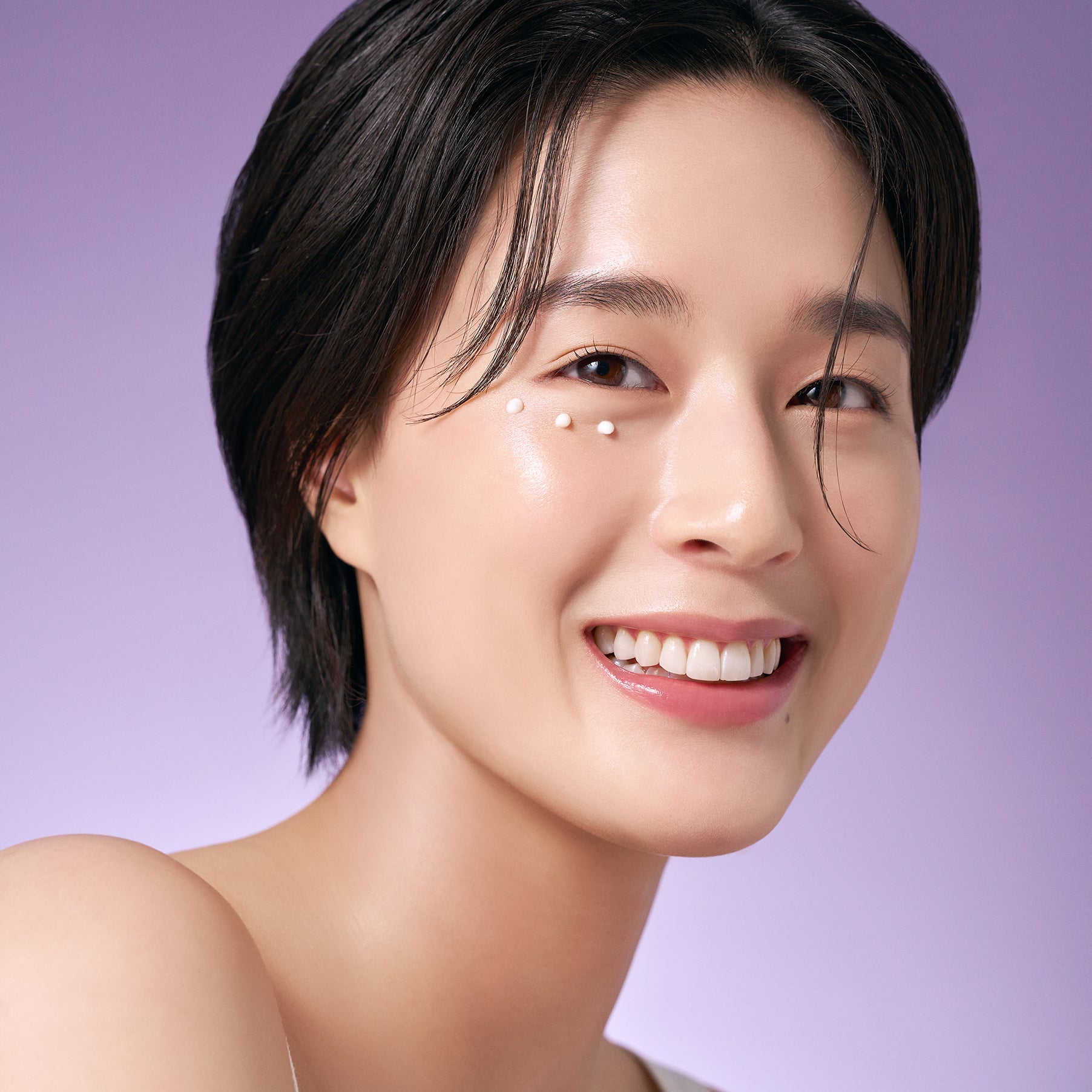 Woman applying PURITO Timeless Bloom Retinol Spot Cream 30ml on her face with a smile, emphasizing skincare benefits.