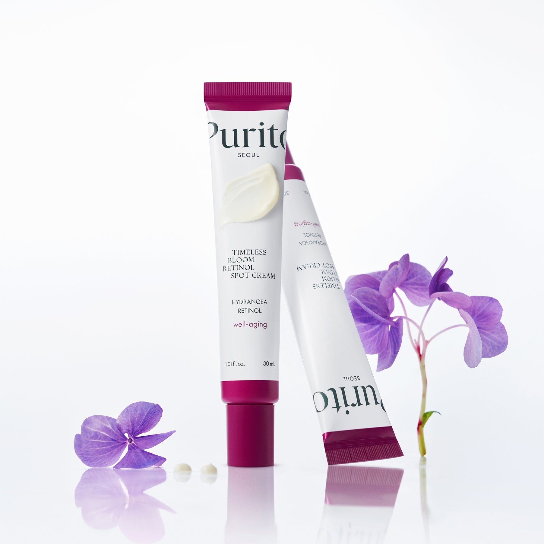 PURITO Timeless Bloom Retinol Spot Cream 30ml tube with purple flowers displayed elegantly.