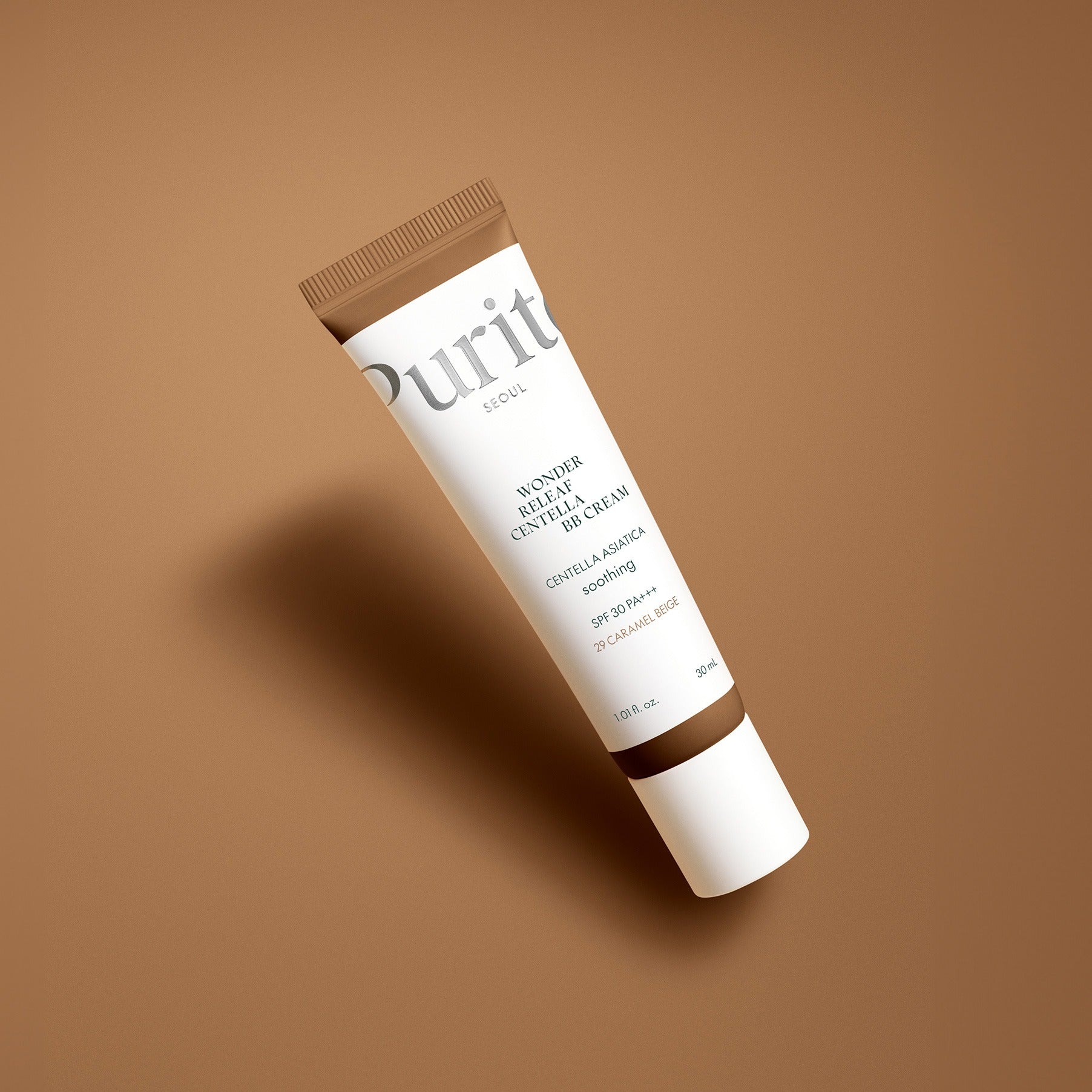 PURITO Wonder Releaf Centella BB Cream 30mml in a brown tube against a soft brown background.