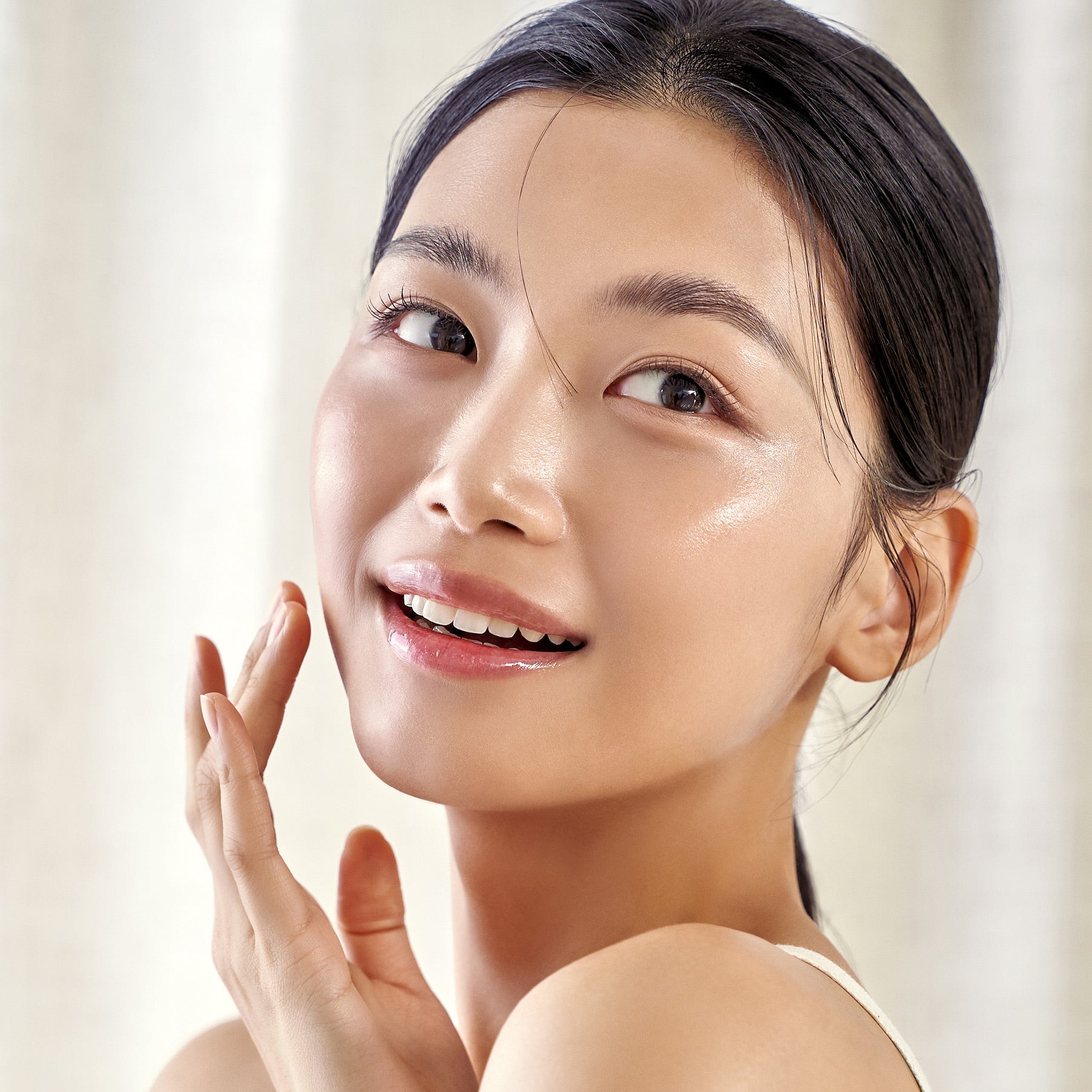Woman with glowing skin using PURITO Wonder Relief Centella Daily Sun Lotion SPF50+PA++++