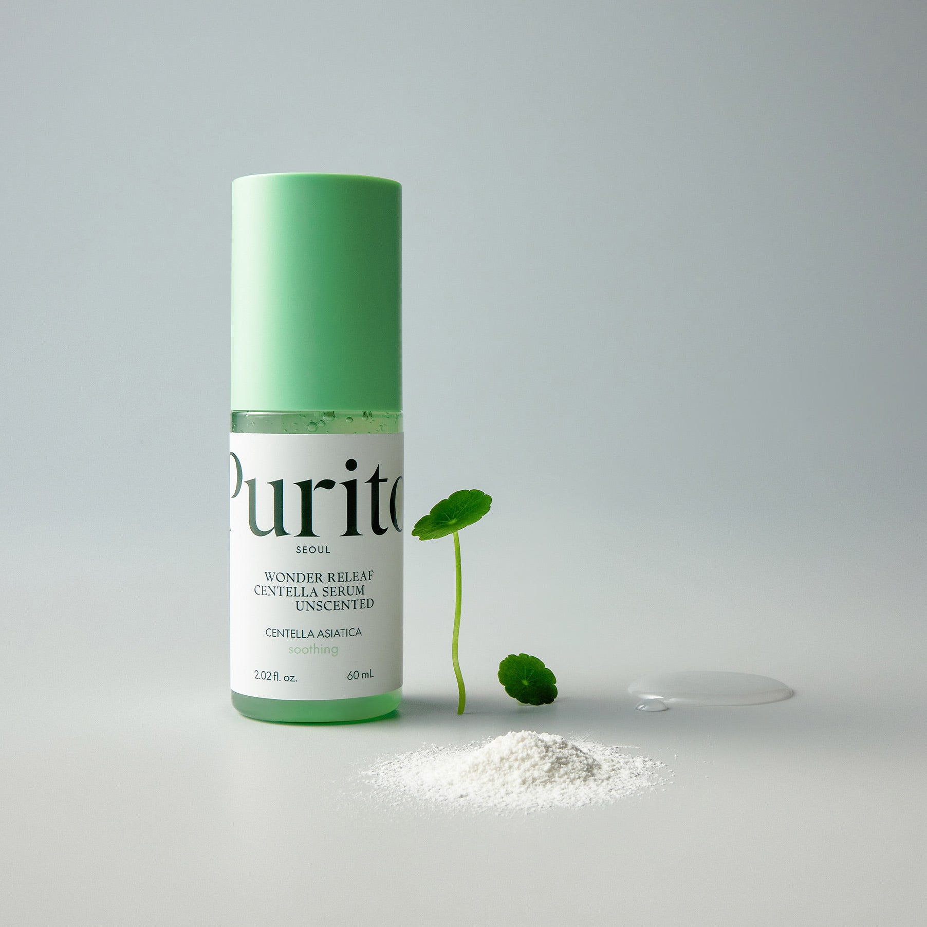 PURITO Wonder Relief Centella Serum Unscented 60ml bottle with green cap, next to centella asiatica leaf and powder.