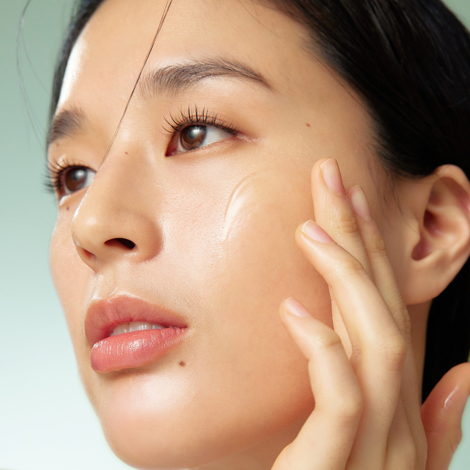 Close-up of person applying PURITO Wonder Relief Centella Serum Unscented 60ml on skin.