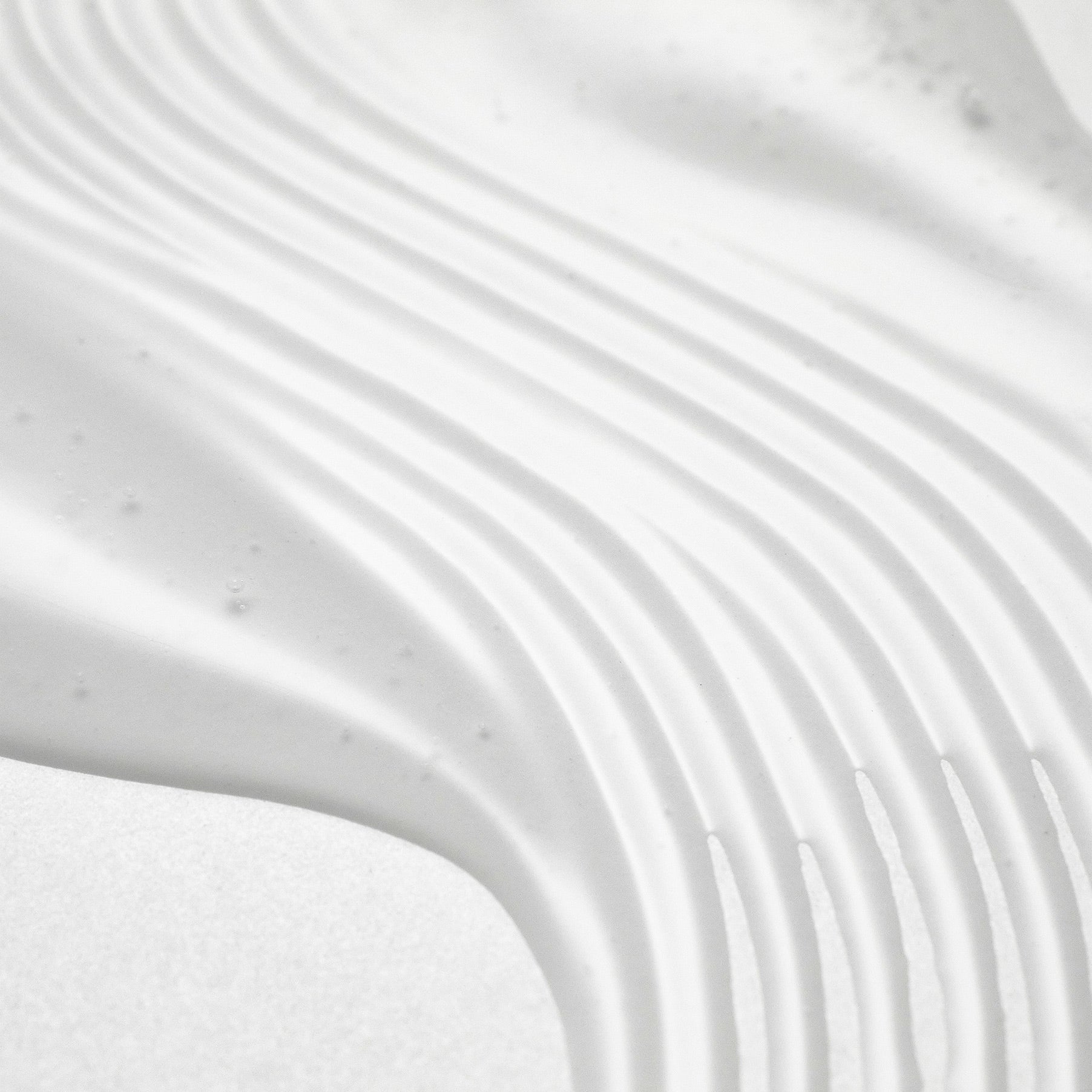 Texture pattern of PURITO Wonder Relief Centella Serum Unscented 60ml with smooth, even application lines. Enhance skincare routine.