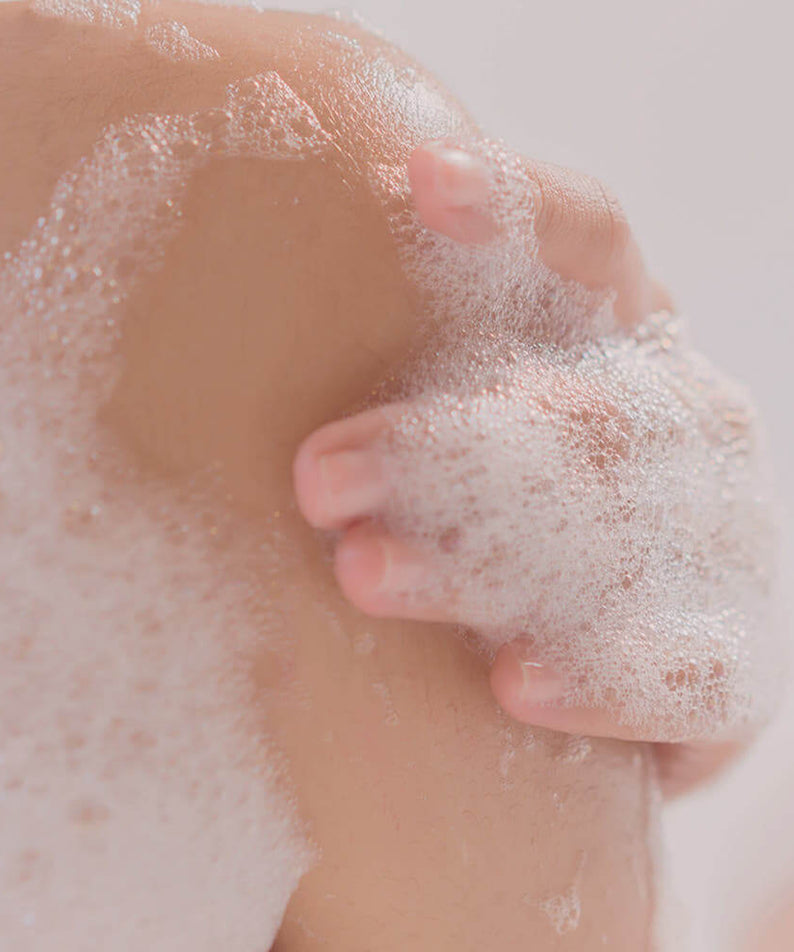 Lather of PYUNKANG YUL Ato Mildly Acidic Moisturizing Body Wash 590ml on skin, showcasing bubbles and gentle cleansing action.