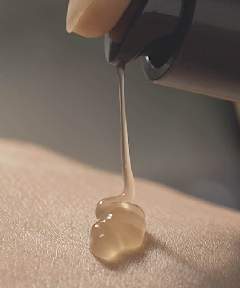 Close-up of PYUNKANG YUL Black Tea Boosting Serum 45ml being dispensed onto skin.