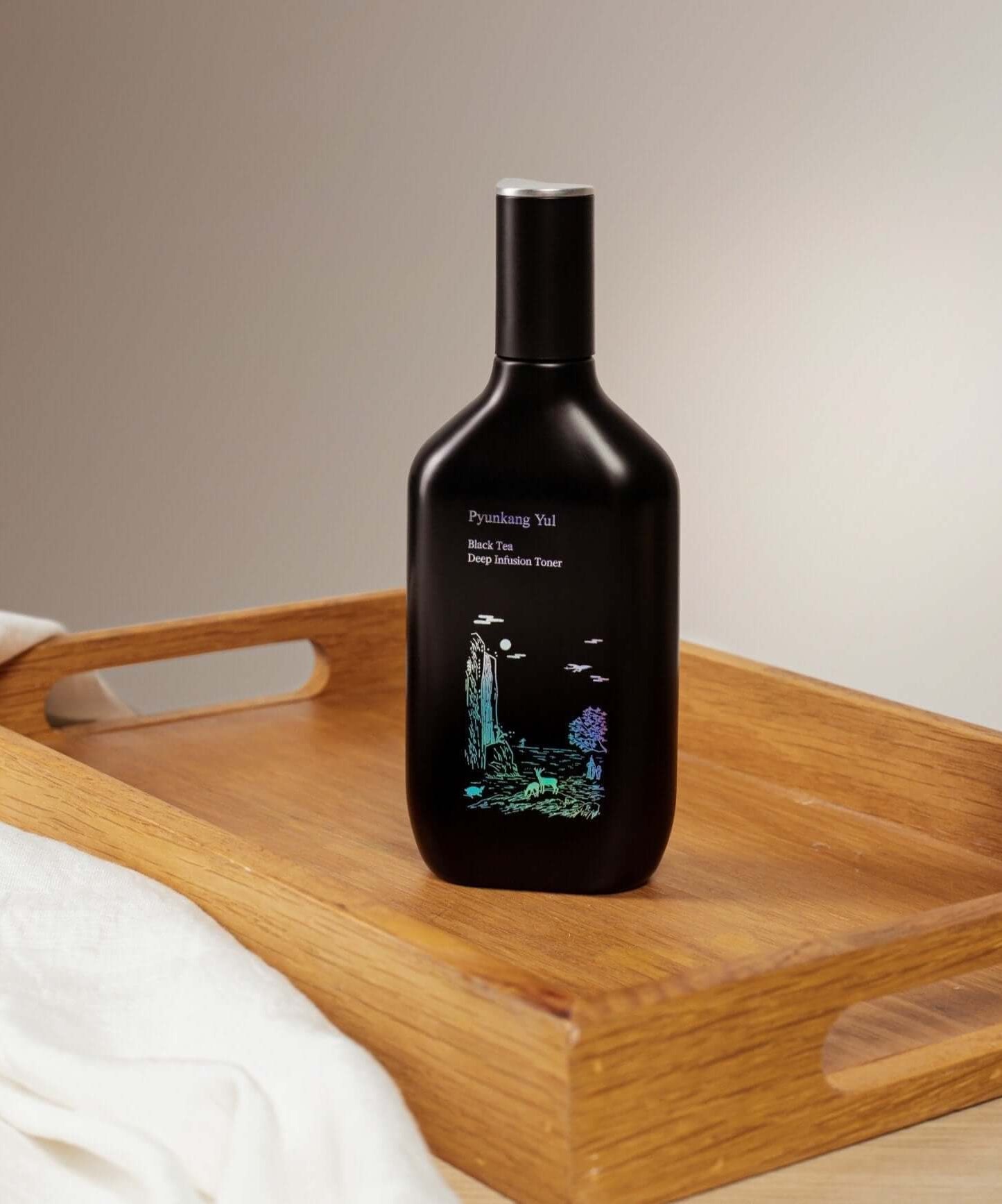 PYUNKANG YUL Black Tea Deep Infushion Toner 130ml bottle on a wooden tray