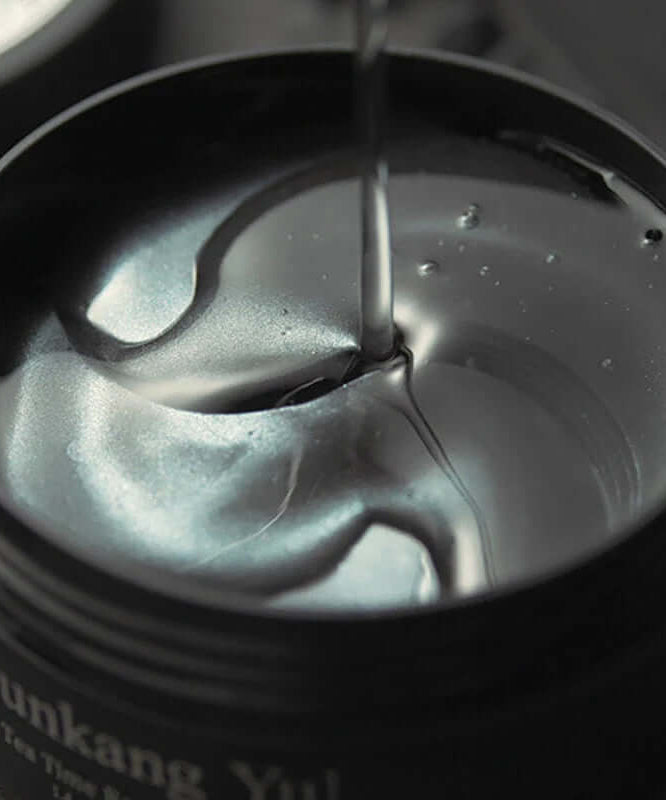PYUNKANG YUL Black Tea Time Reverse Eye Patch 60 Sheets in open container showcasing glossy texture, perfect for rejuvenating eyes.