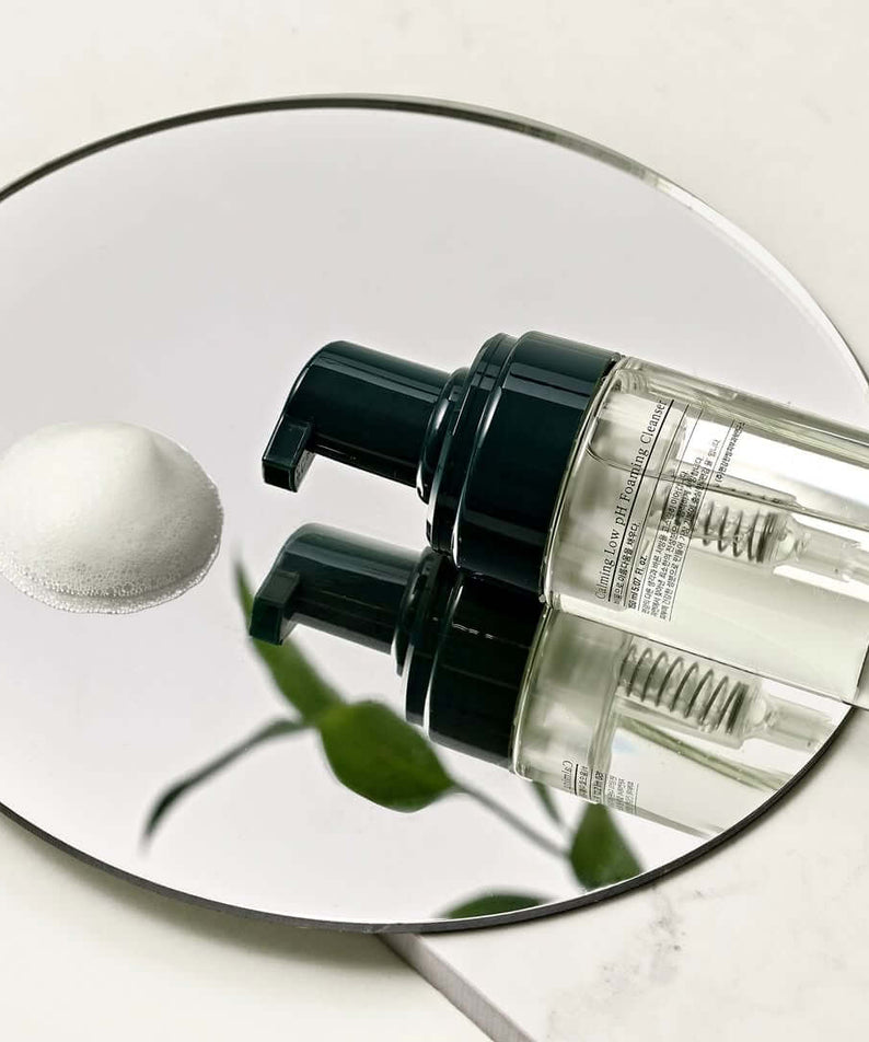 PYUNKANG YUL Calming Low pH Foaming Cleanser 150ml bottle on mirrored surface with foam