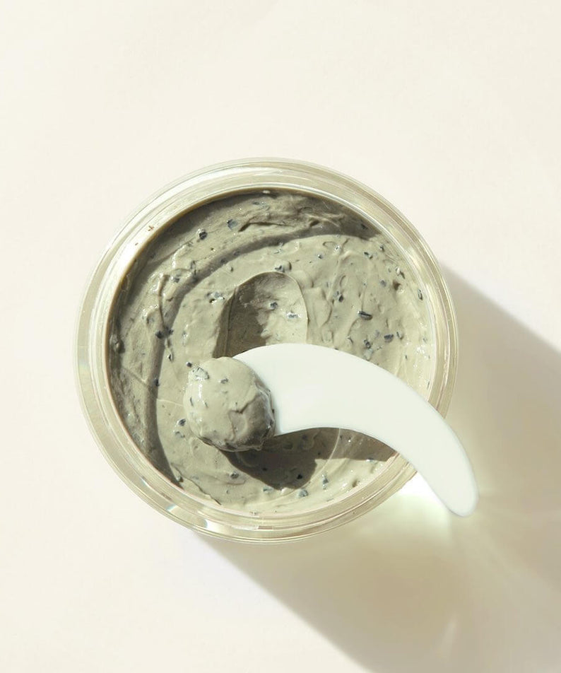 Open jar of PYUNKANG YUL Calming Pore Clear Wash Off Pack 100ml with a spatula on a neutral background.