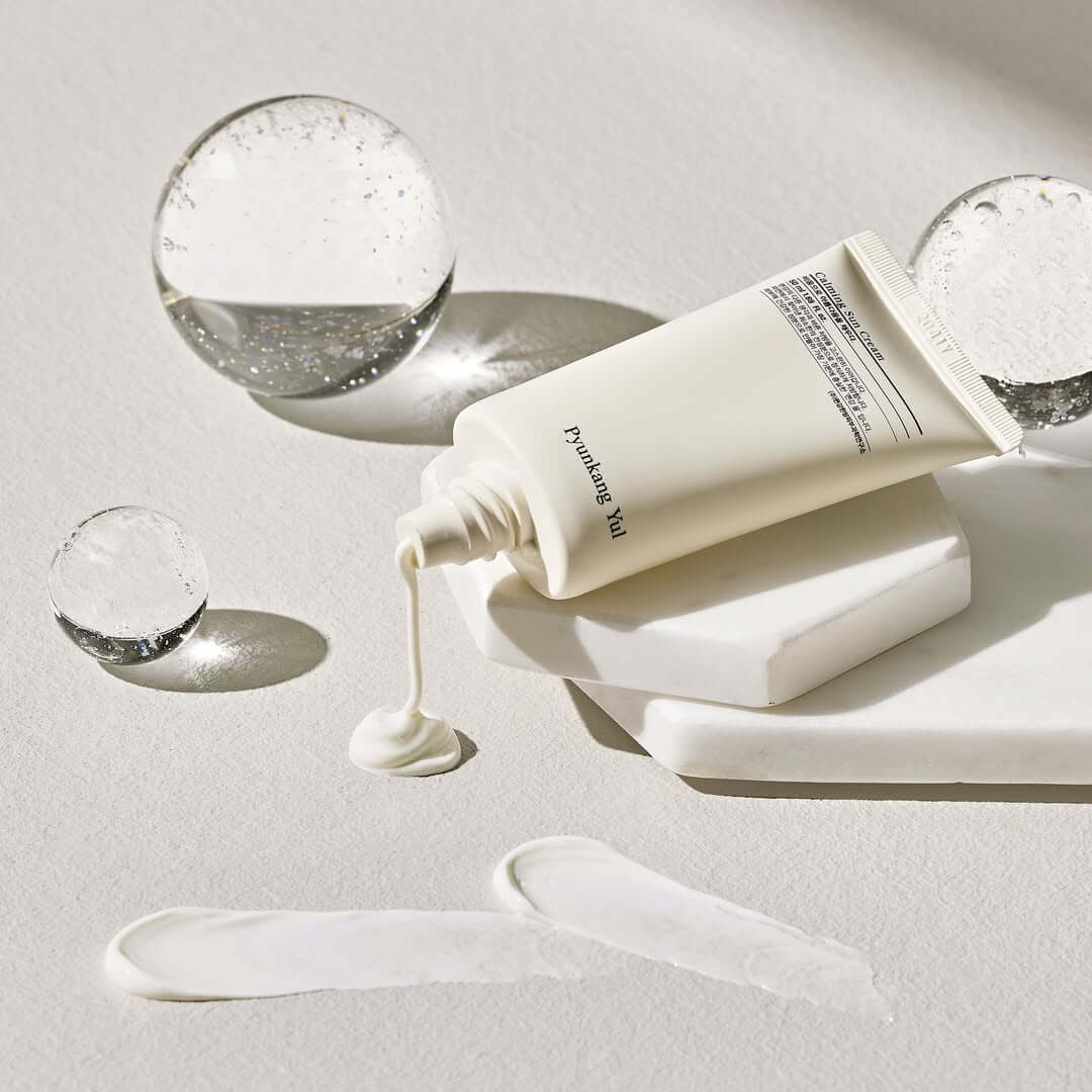 PYUNKANG YUL Calming Sun Cream SPF+PA++++ 50ml displayed with elegant product styling on a textured surface.
