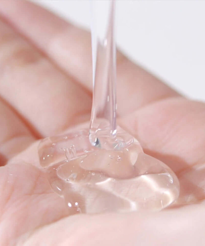 Clear gel texture of PYUNKANG YUL Low pH Scalp Shampoo 500ml in hand