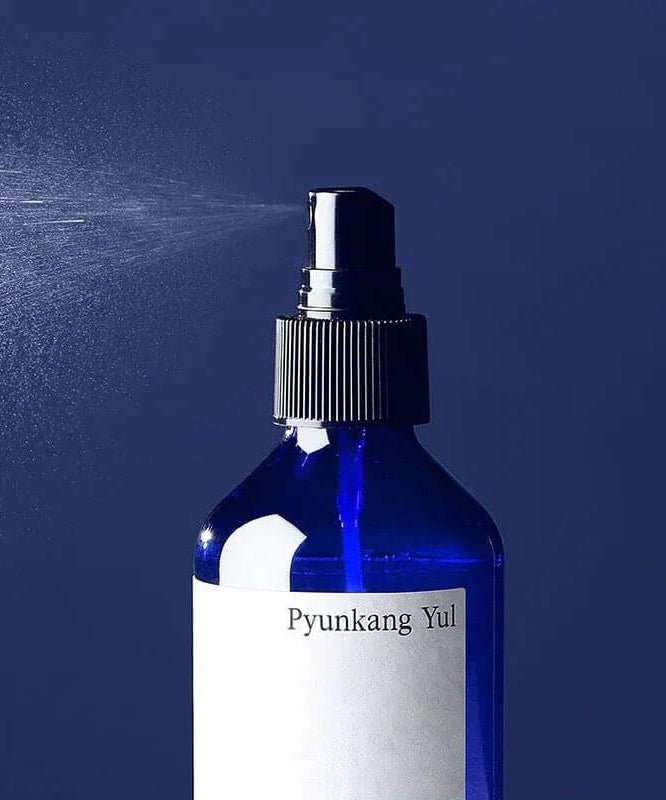 PYUNKANG YUL Mist Toner 200ml bottle spraying fine mist on blue background.