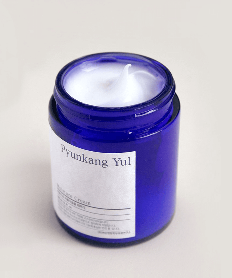 Open jar of PYUNKANG YUL Moisture Cream 100ml with white cream inside and blue container.