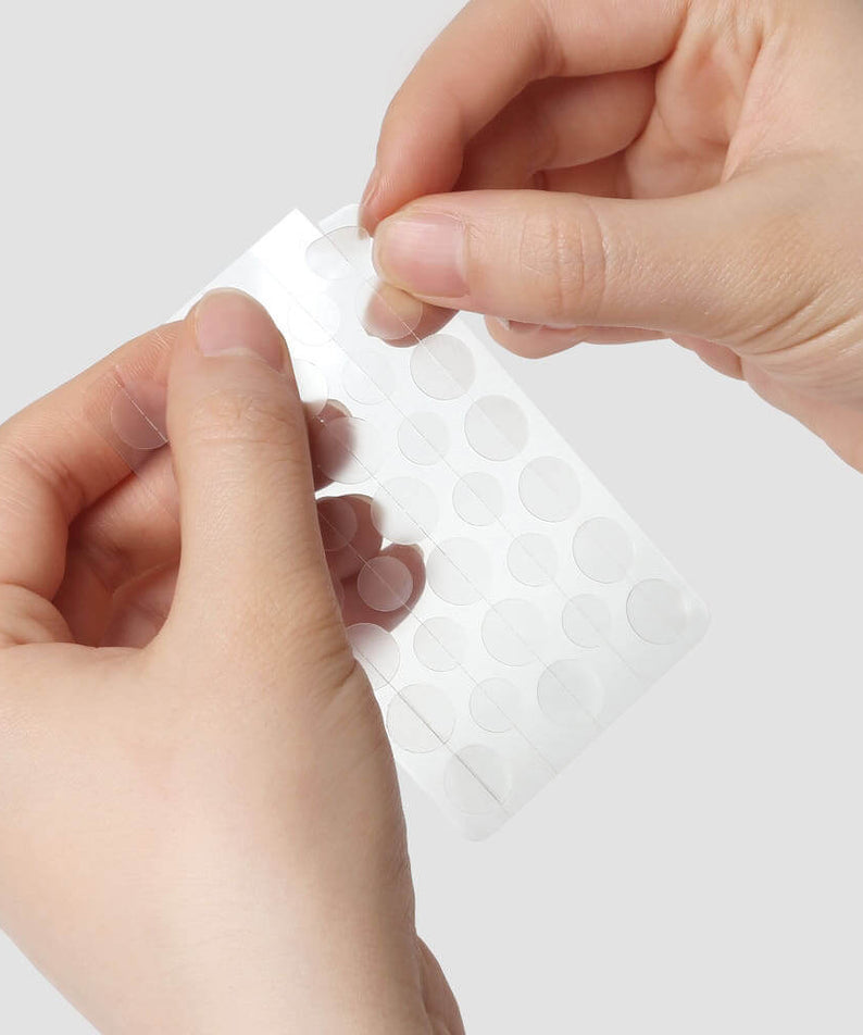 Hands holding PYUNKANG YUL True Clear Spot Patch Intensive Care Vibevel 165 pcs, transparent acne care dots.